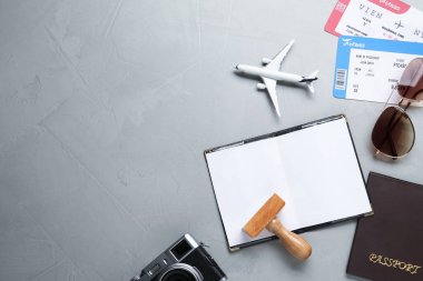 Pasaport ve vize damgalı düz kompozisyon gri masada. Metin için boşluk