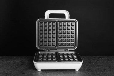 Koyu gri masada elektrikli waffle makinesini aç