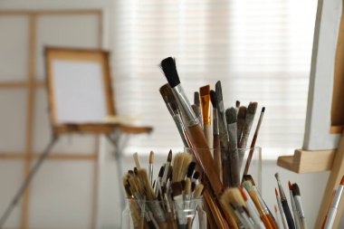 Stüdyoda farklı boya fırçaları olan tutucular, yakın plan. Sanatçının işyeri