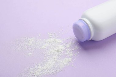 Leylak arka planında şişe ve toz alma tozu, yakın plan. Bebek kozmetik ürünü