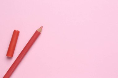 Pembe arka planda dudak kalemi, metin için yeri olan düz bir yer. Kozmetik ürünü