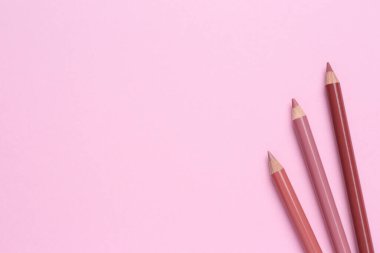 Pembe arka planda dudak kalemi, metin için boşluk. Kozmetik ürünü