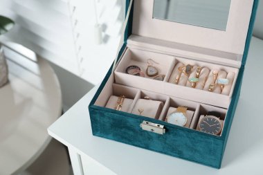 Güzel bijouterie ve beyaz masanın üzerinde pahalı kol saatleri olan zarif mücevher kutusu.