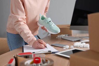 Ofisteki masada çalışan ayakkabı satıcısı, yakın plan. Çevrimiçi mağaza