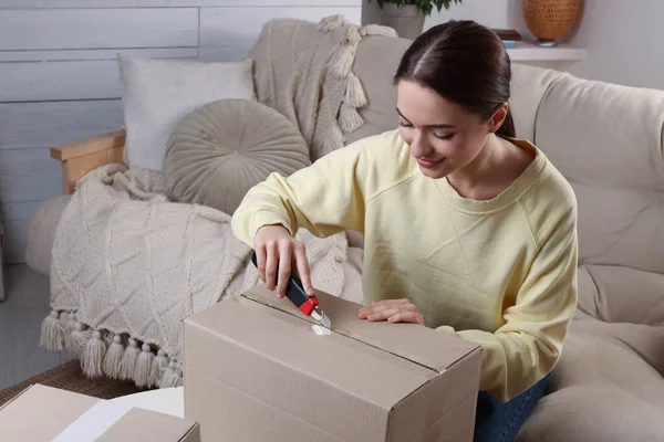 Ung Kvinna Använder Verktygskniv För Att Öppna Paket Hemma — Stockfoto