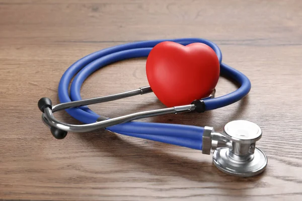 立体镜和红心放在木制桌子上 心脏科概念 — 图库照片