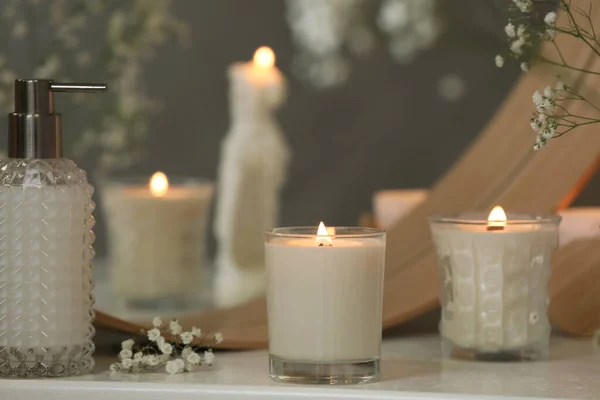 鏡の近くの白いテーブルの上に美しい燃焼キャンドルやジプシーの花室内 — ストック写真