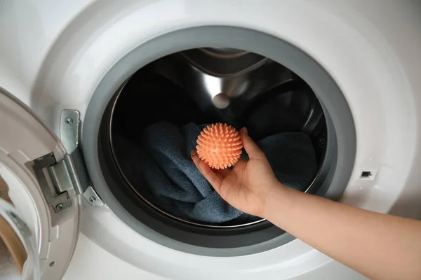 洗濯機にドライヤーボールを入れる女 — ストック写真