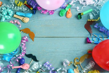 Gri ahşap arka planda renkli yılan desenli süslemeler ve diğer parti aksesuarları düz yatıyordu. Metin için boşluk