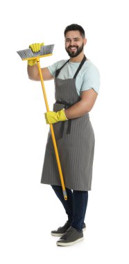 Beyaz arka planda sarı süpürgesi olan genç bir adam.