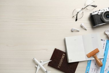 Pasaportlu düz kompozisyon, beyaz ahşap masa üzerinde pul ve uçuş biletleri, metin için boşluk