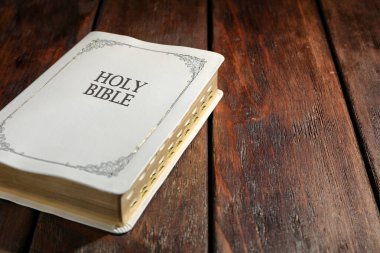 Ahşap masada eski ciltli İncil, yazı için yer. Dini kitap
