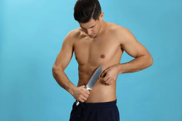 ナイフで男にフィットし ライトブルーの背景に体にマーク 減量手術 — ストック写真