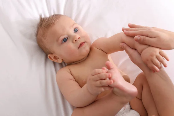 Mãe Massageando Seu Bebê Bonito Com Óleo Cama Close — Fotografia de Stock