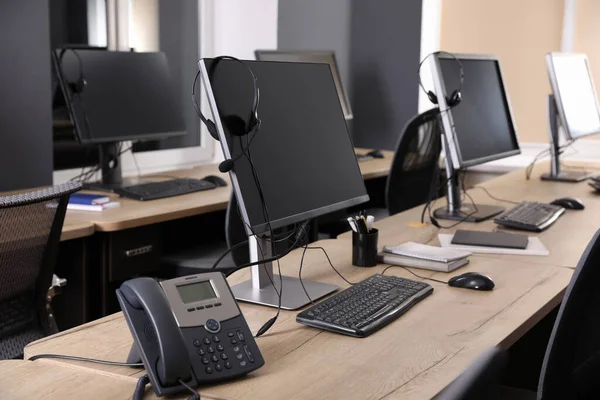 Moderne Computer Mit Headsets Und Stationärem Telefon Auf Holzschreibtisch Büro — Stockfoto
