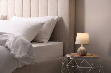 Kaliteli lamba ve dergi kapalı bir komodinin üzerinde. Yatak odasının iç kısımları