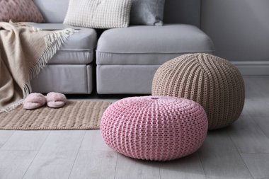 Oturma odasındaki kanepenin yanında süslü püslü puflar. İç öge