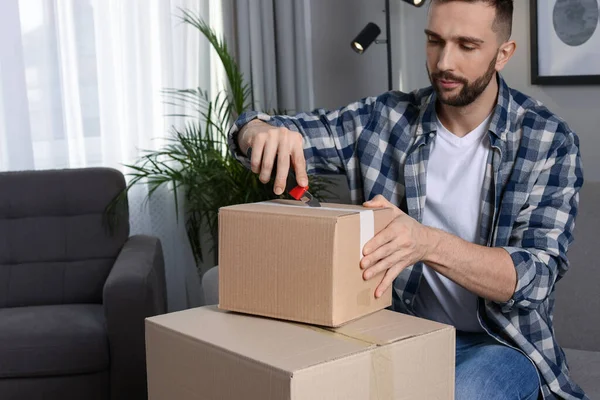 Man Använder Verktygskniv För Att Öppna Paket Hemma — Stockfoto