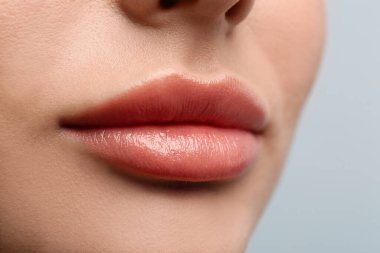 Açık arkaplanda güzel dudakları olan bir kadının yakın görüntüsü