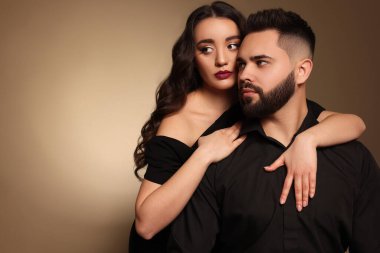 Açık kahverengi arka planda seksi bayan olan yakışıklı sakallı adam. Metin için boşluk