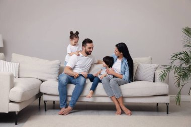 Mutlu aile oturma odasındaki kanepede dinleniyor.