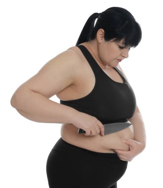 Beyaz arka planda bıçaklı obez kadın. Kilo kaybı ameliyatı