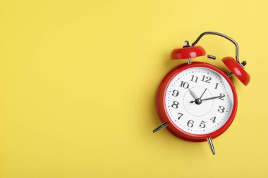Sarı arkaplandaki alarm saati, metin için yeri olan üst görünüm. Okul zamanı.