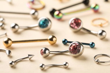 Bej arka planda piercing için şık mücevherler, yakın plan