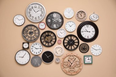 Bej duvarda şık saat koleksiyonu