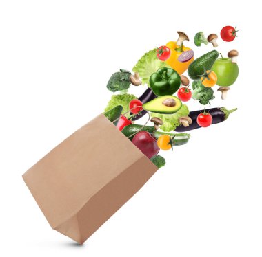 Beyaz arka planda farklı meyve ve sebzelerle dolu kese kağıdı.