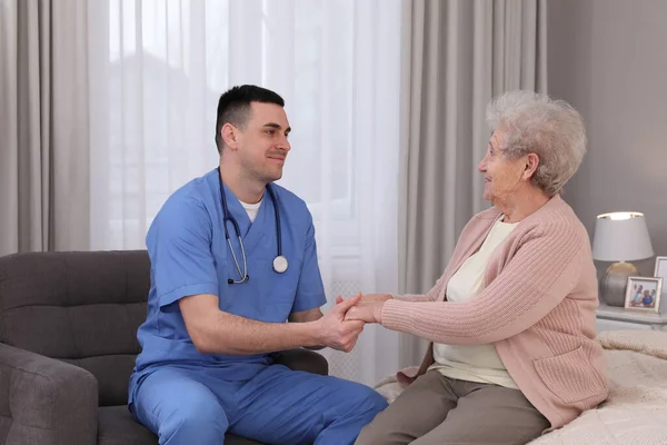 若い介護者は寝室で先輩女性と話をする 在宅医療サービス — ストック写真