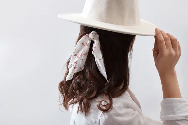 帽子とスタイリッシュなバンダナを背景にした若い女性 バックビュー — ストック写真