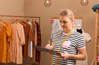 Dressmaker atölyede kıyafet çizimi yapıyor, metin için boşluk
