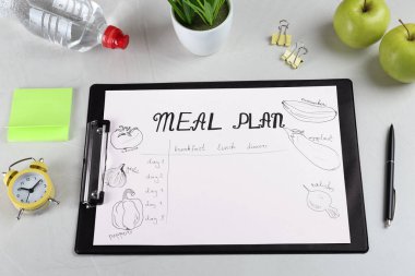 Açık gri masa üzerinde Menü Planı olan panonun bileşimi, üst görünüm