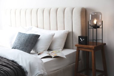 İçerideki komodinin üzerinde şık bir lamba ve çalar saat var. Yatak odasının iç kısımları