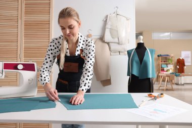 Atölyede terzi kumaşı tebeşirle işaretliyor