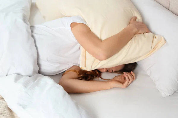 ベッドで枕で頭をカバーし 眠れない女性 上のビュー — ストック写真