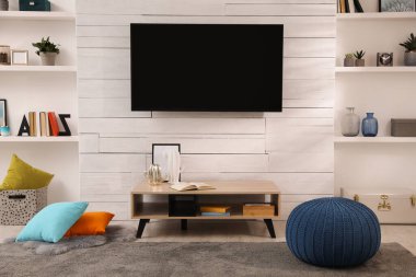 Şık dekorlar ve modern televizyonlarla dolu rahat bir oda.
