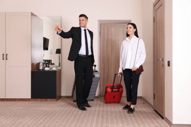 Bavulları olan mutlu iş adamları otel odasına giriyor.