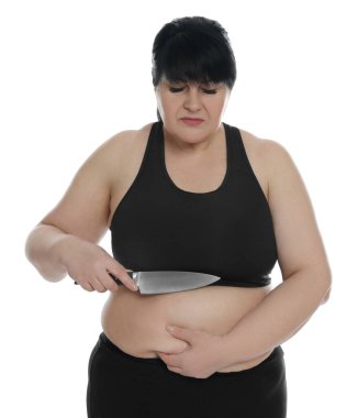 Beyaz arka planda bıçaklı obez kadın. Kilo kaybı ameliyatı