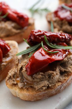 Lezzetli etli börek, kurutulmuş domates ve beyaz tahtada biberiye, yakın plan.