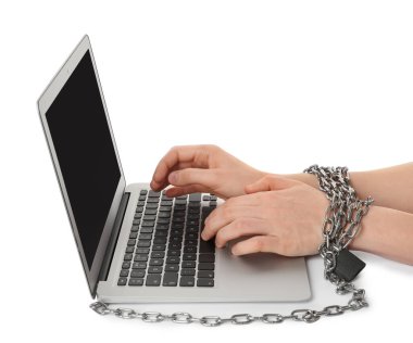 Elleri zincirli bir kadın dizüstü bilgisayarında beyaz arka plana karşı yazı yazıyor, yakın plan. İnternet bağımlılığı