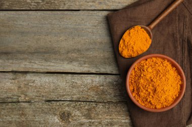 Ahşap masa üzerinde safran tozlu kase ve kaşık, üst manzara. Metin için boşluk