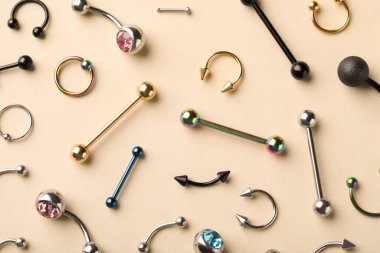 Bej arka planda piercing için şık mücevherler, düz yatış