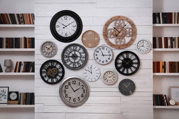 部屋の本棚の間に異なる時計のコレクション インテリアデザイン — ストック写真