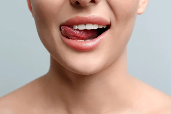 Frau Leckt Ihre Lippen Auf Hellem Hintergrund Nahaufnahme — Stockfoto