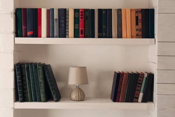Полки Різними Книгами Лампами Світлій Стіні — стокове фото