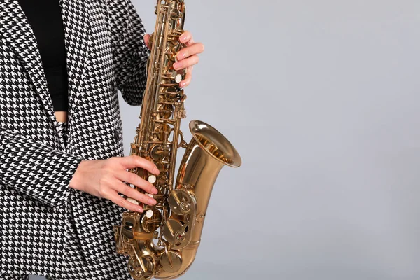 Kobieta Eleganckim Garniturze Saksofonem Szarym Tle Zbliżenie Miejsce Tekst — Zdjęcie stockowe