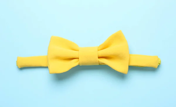 明るい青の背景にスタイリッシュな黄色の弓のネクタイ トップビュー — ストック写真