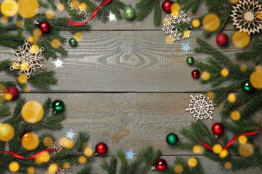 Noel tebrik kartı ve mesaj için yer var. Köknar ağacı dallarının düz kompozisyonu ve ahşap arka planda şenlikli dekor.